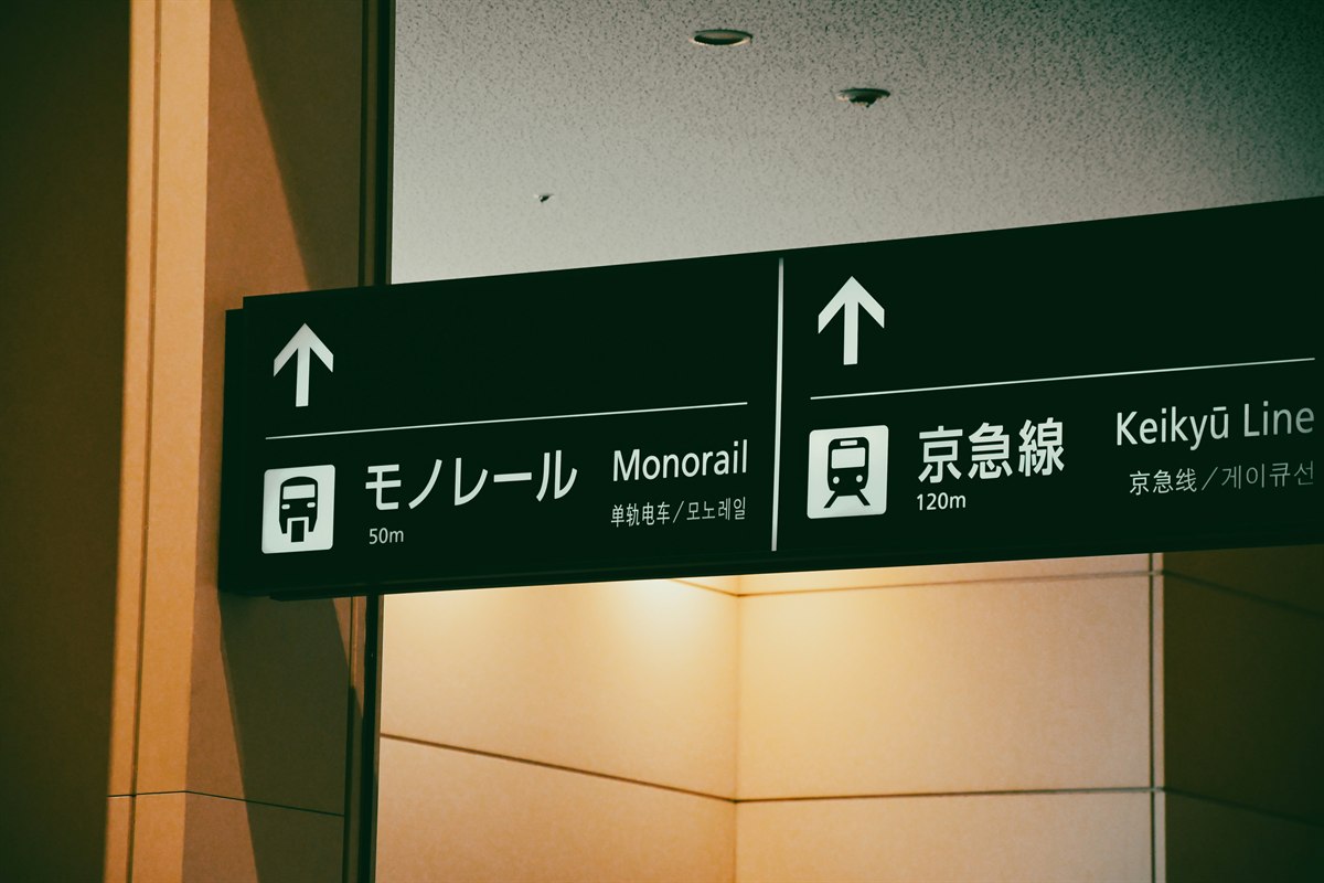 Signs at Haneda Airport pointing to the monorail and the Keikyu Line.