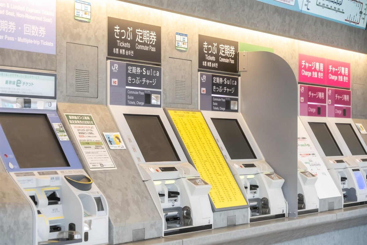 JR East ticket machines. The signs above read "Commuter Pass · Suica / Tickets / Charge".